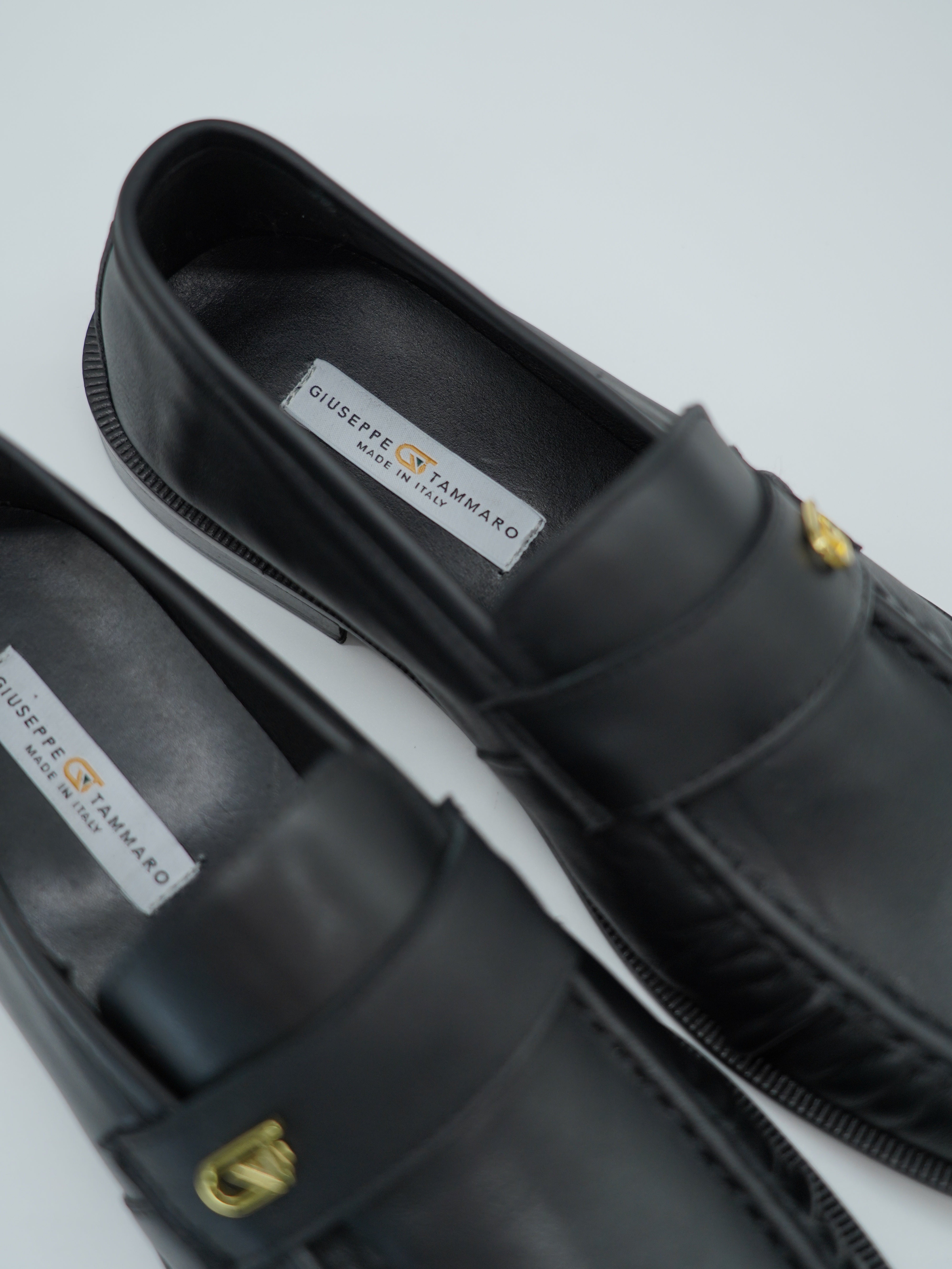 Mocassino tubolare in pelle sauvage nera con arriccio e fibbia GT in metallo oro