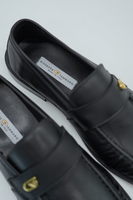 Mocassino tubolare in pelle sauvage nera con arriccio e fibbia GT in metallo oro