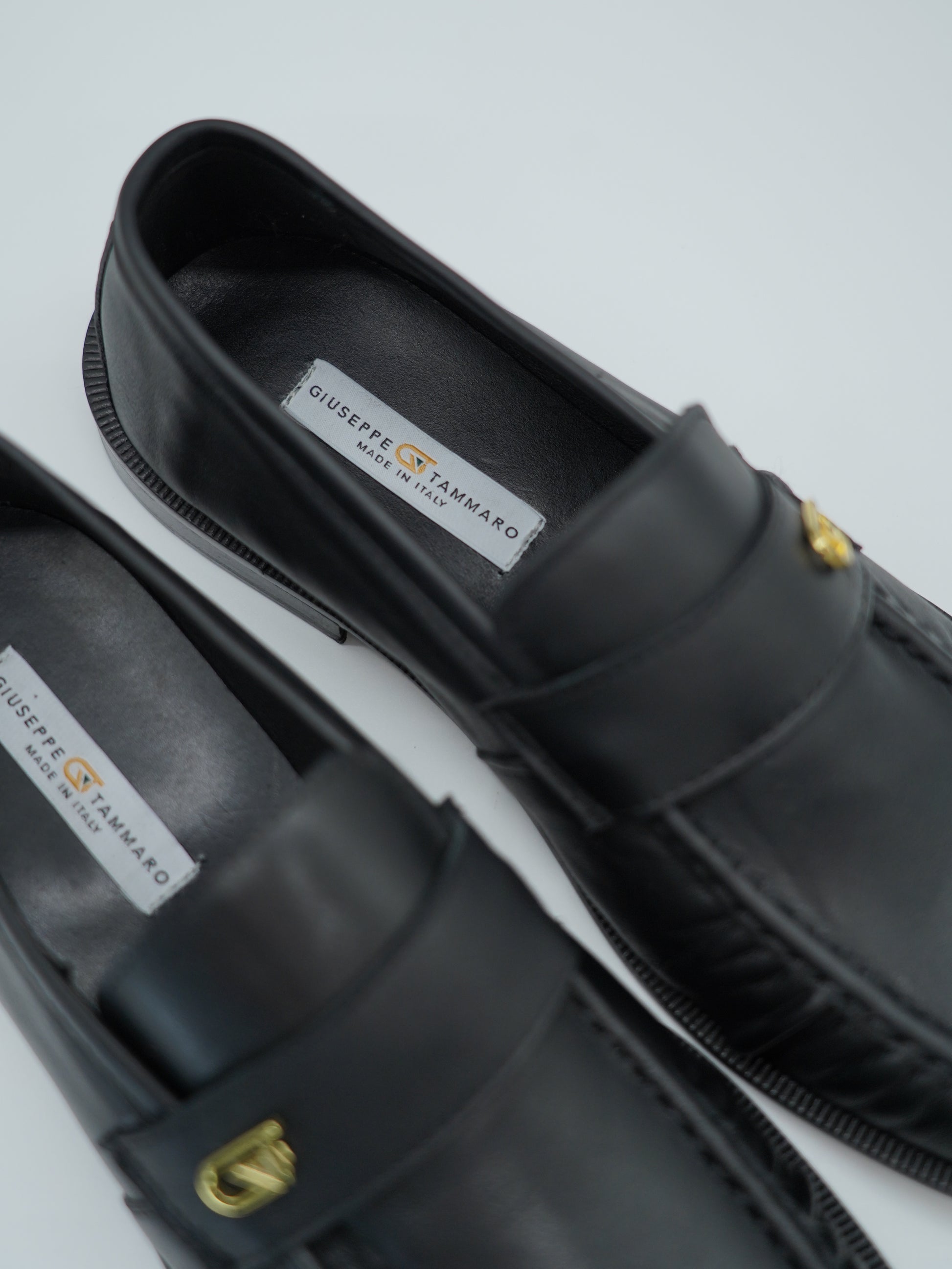 Mocassino tubolare in pelle sauvage nera con arriccio e fibbia GT in metallo oro