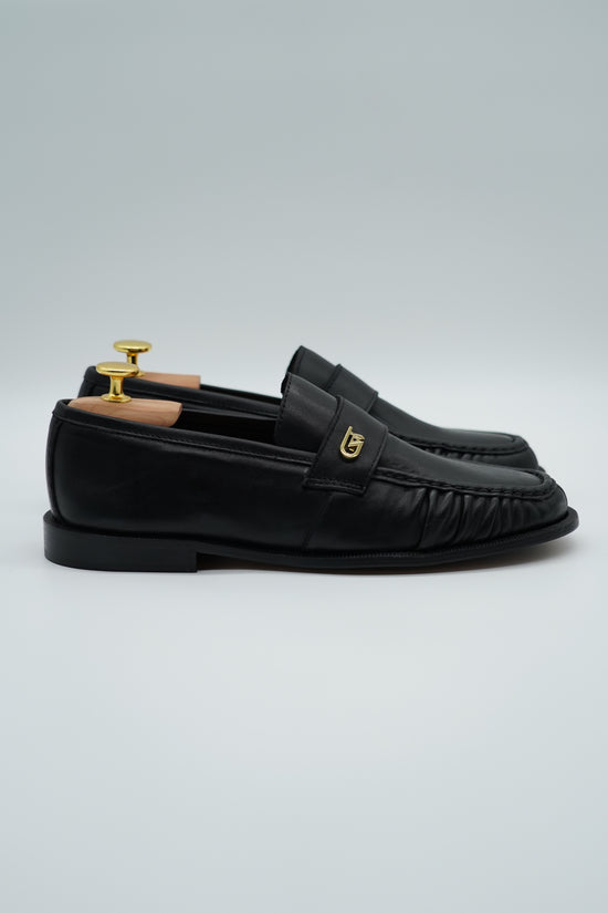 Mocassino tubolare in pelle sauvage nera con arriccio e fibbia GT in metallo oro