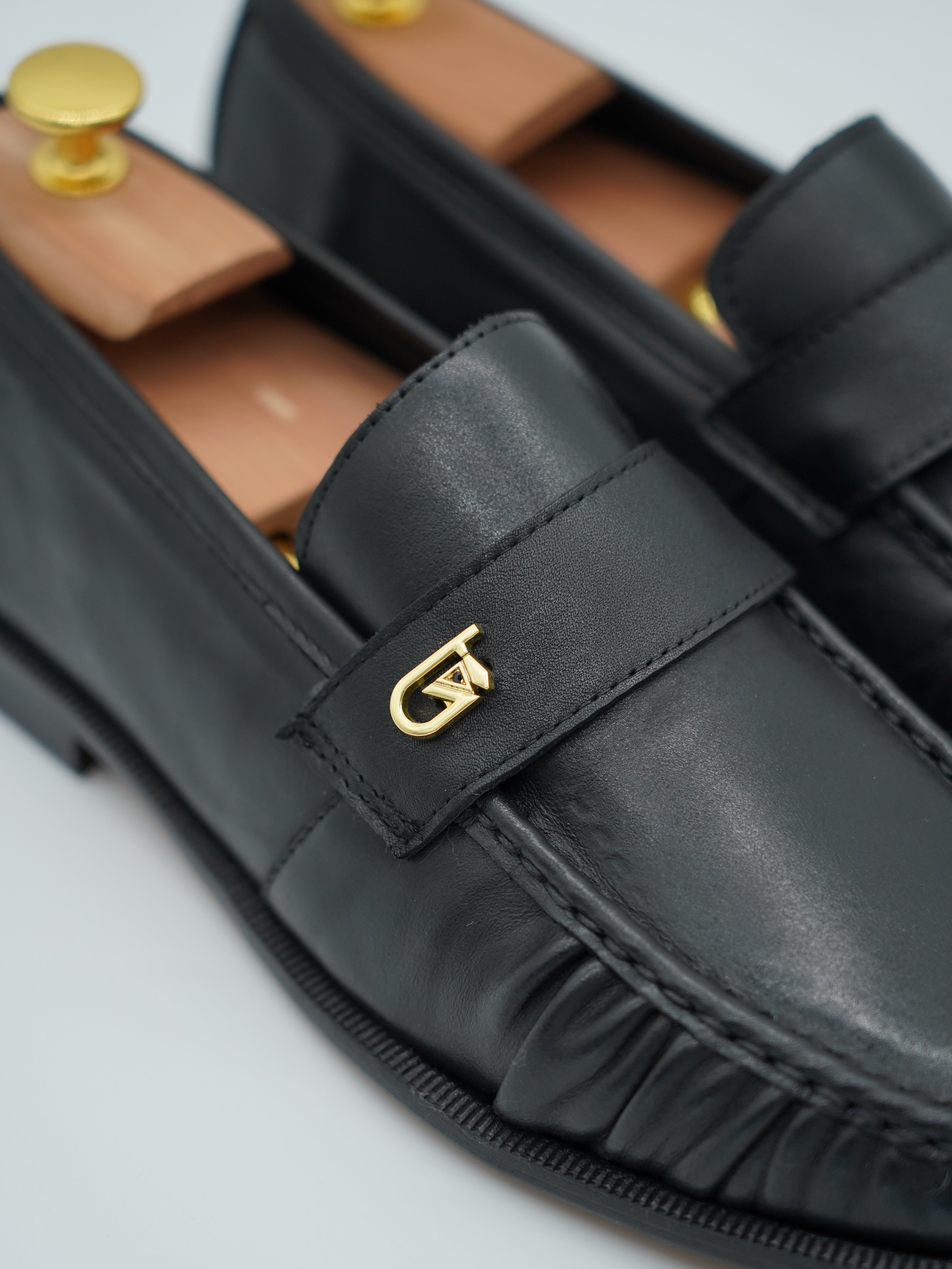 Mocassino tubolare in pelle sauvage nera con arriccio e fibbia GT in metallo oro