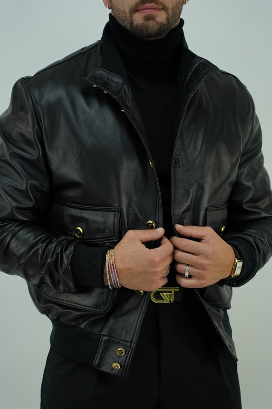 Giubbino in pelle nero con bottoni oro